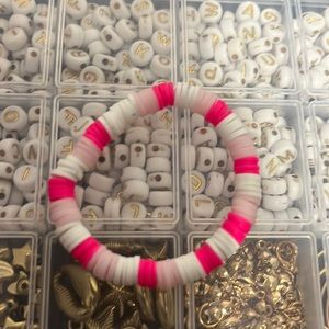 It is a preppy hot pink, light pink and white clay bead bracelet